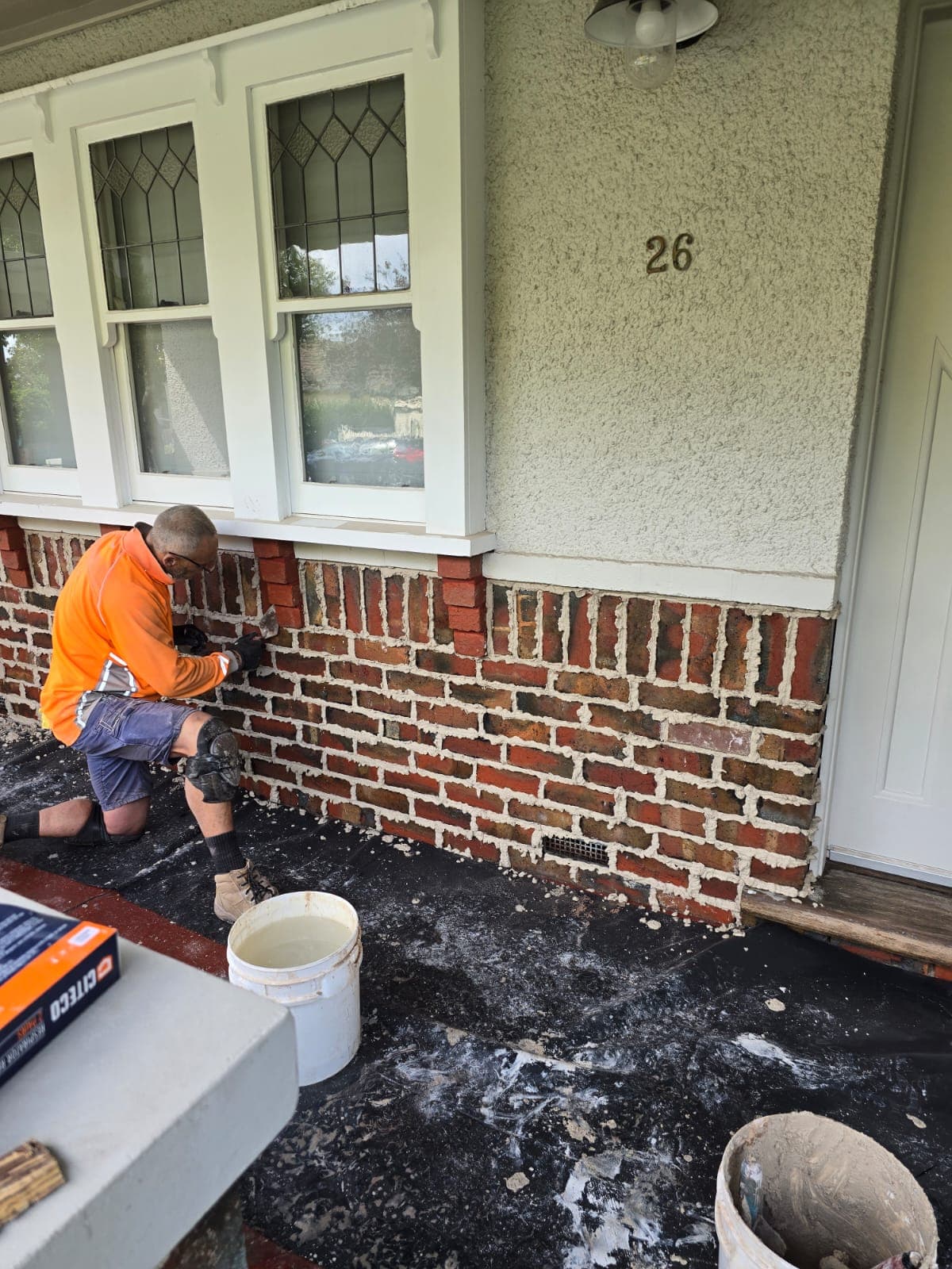 Tradesperson hand-finishing tuck pointing on a weathered heritage brick facade by Goodwin Bricklaying